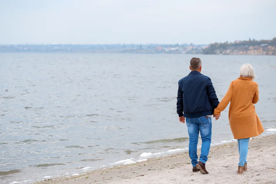 Pareja mayor abrigada caminando al aire libre en un día frío