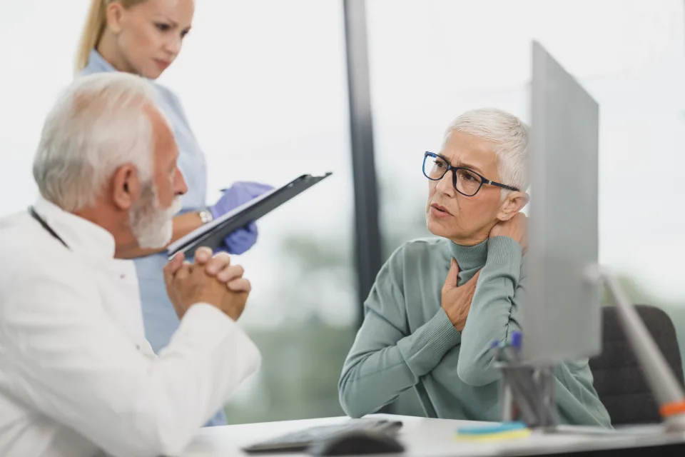 Mujer mayor revisando con su médico los resultados que aparecen en la pantalla